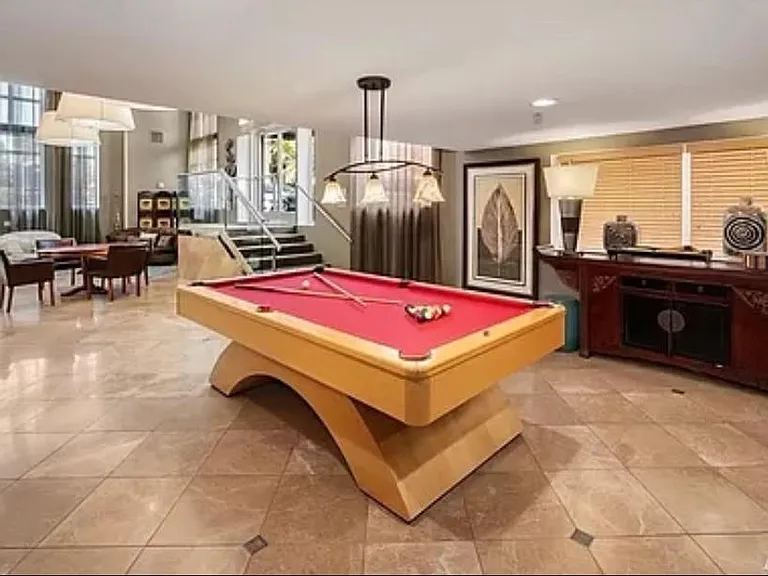 Entertainment area with billiards, seating areas, television, fireplace.