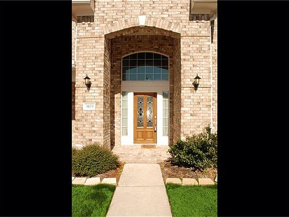 Professional landscaping greets your guests under the covered entry
