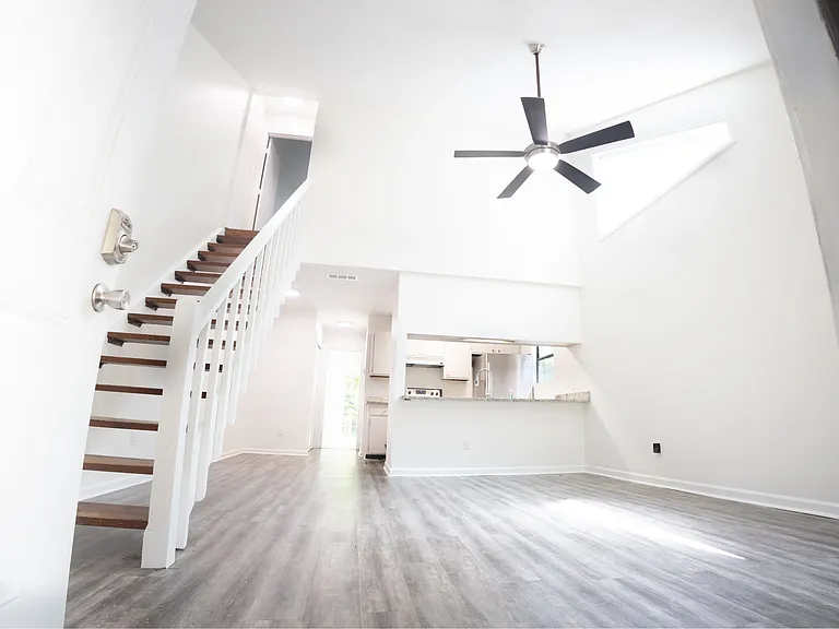 Bright living room with vaulted ceilings and open stairwell
