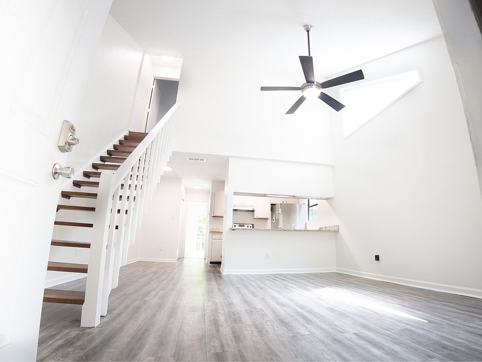 Bright living room with vaulted ceilings and open stairwell