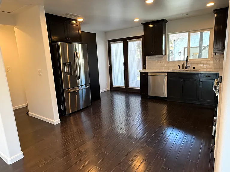 Kitchen with abundant storage, stainless steel appliances, dimmable recessed LED lighting, and views of the backyard and patio