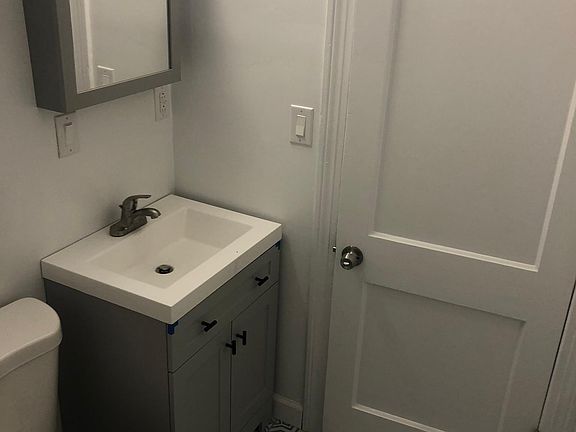 Newly updated bathroom with decorative tile floor, subway tile shower, and new vanity and mirror.