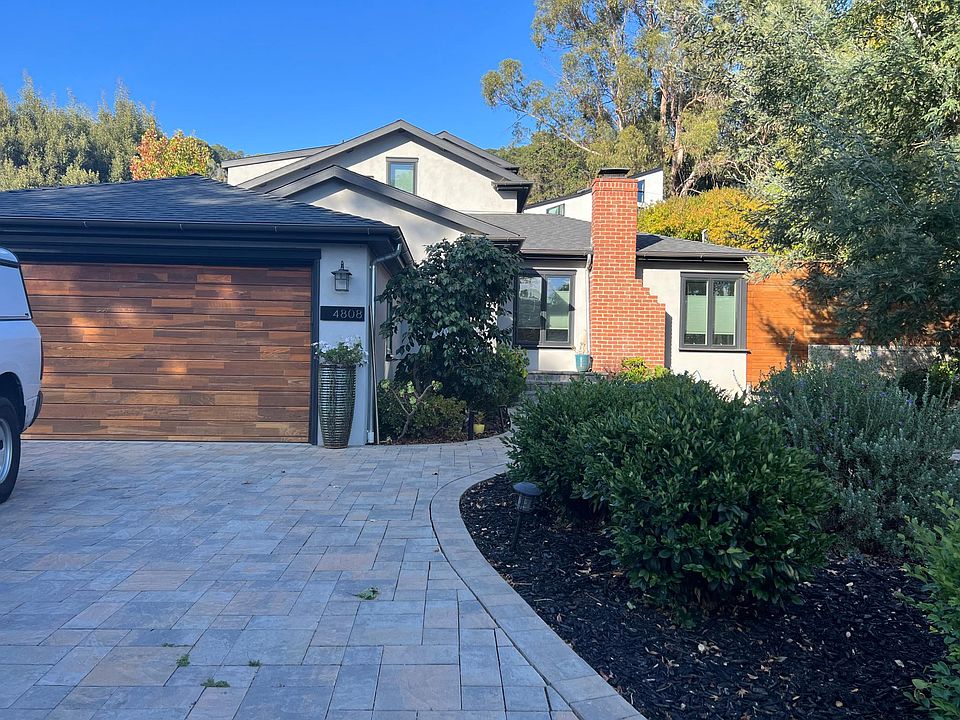 Street view of the house. Large drought resistant yard with a path and seating area