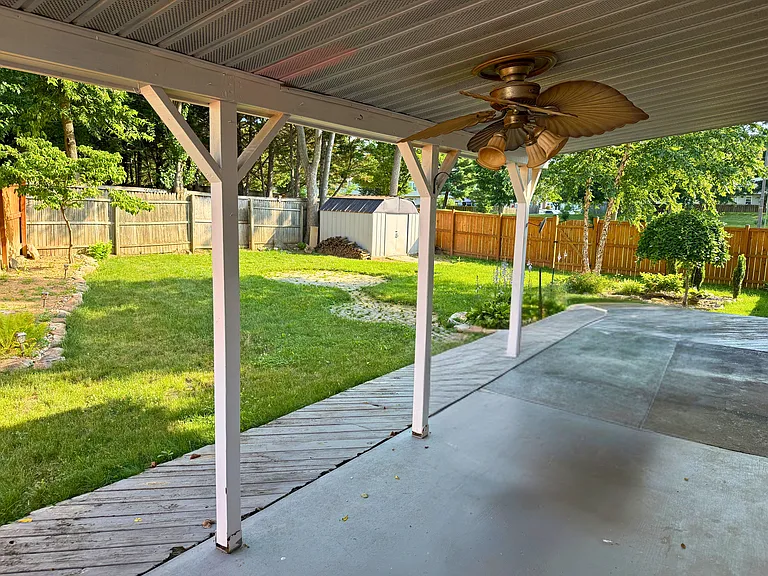 Fully fenced backyard with a covered patio