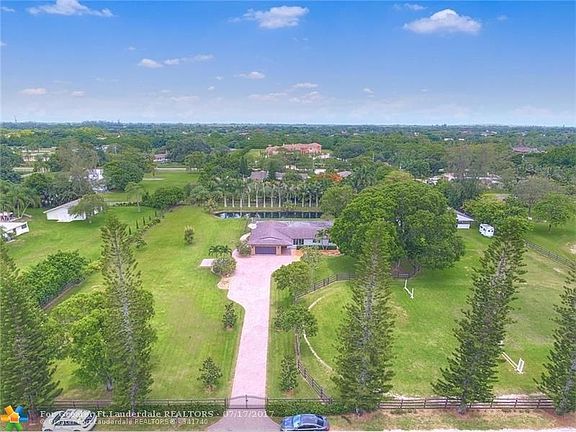 Aerial of oversized Parkland Ranches equestrian property with home, pool, pond, barn, paddocks and ring. Come enjoy stylish country living that is surprisingly close to the city!