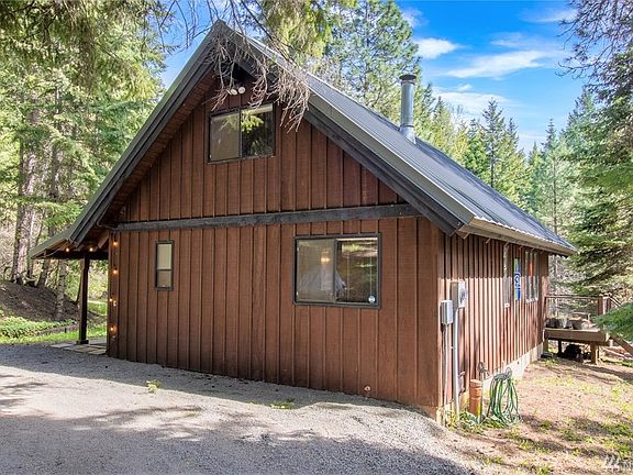Metal roof and wood siding blend well into the natural landscape of the area. Entrance to the house is on the left.