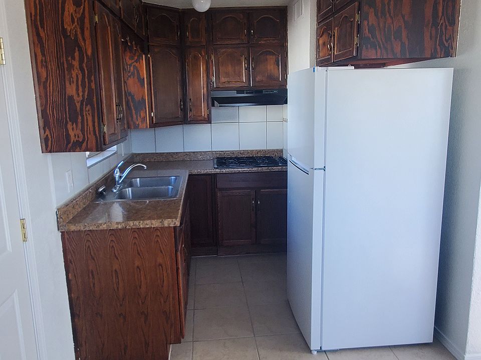 Kitchen area, cabinets, refrigerator and cook-top.