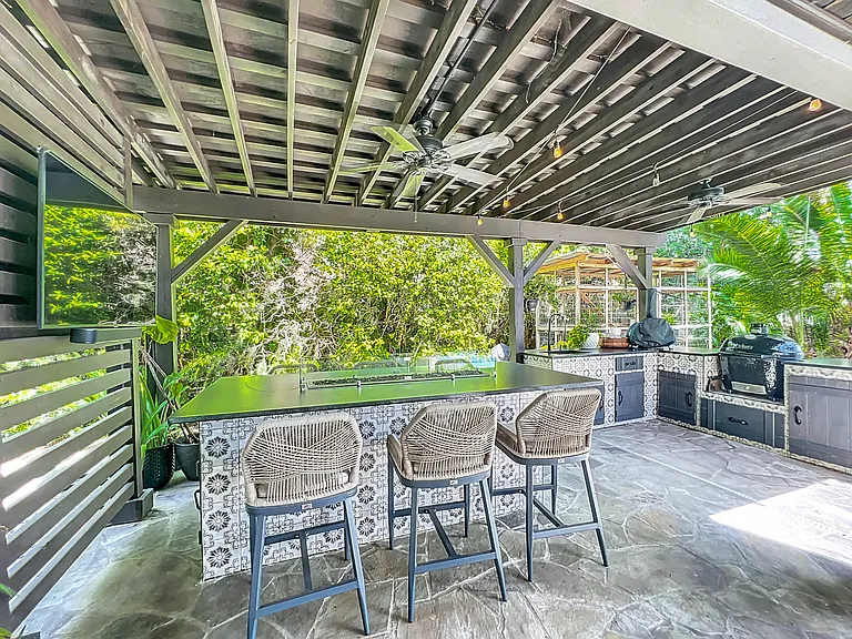 Outdoor Kitchen with sink, fridge, smoker, gas pizza oven and Bar with gas fire pit and TV