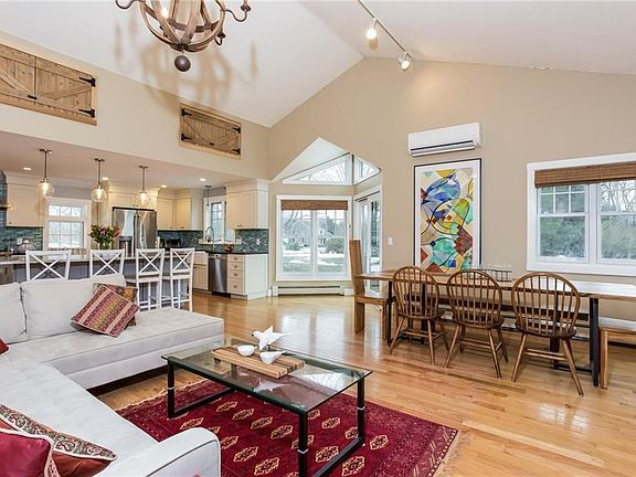 Living room facing alcove and large dining area with a peek of the kitchen on the left