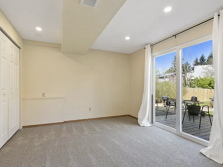 Available bedroom on the lower level with sliding door to the patio facing peaceful back yard.