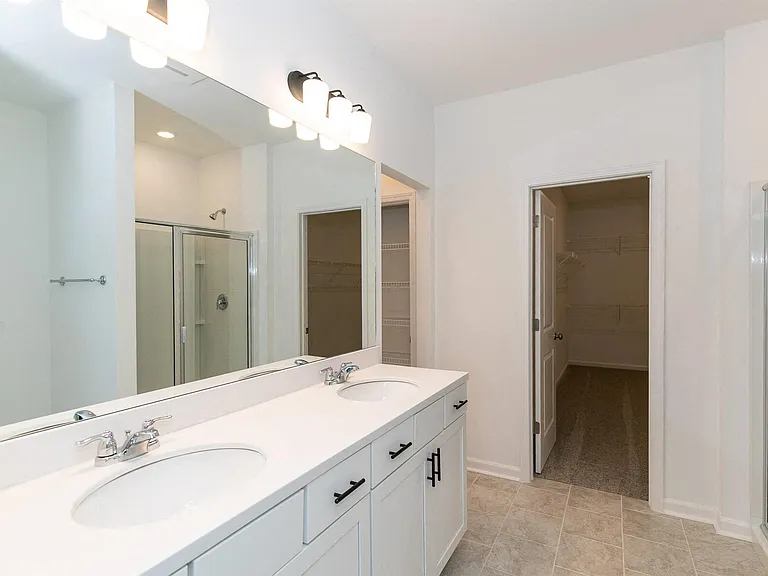 Primary bathroom with double vanity, and walk-in shower.