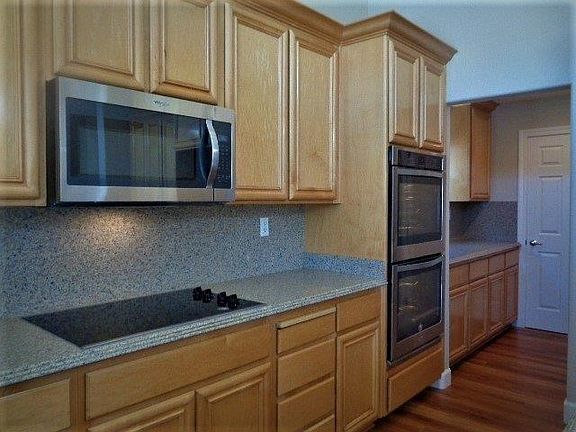 Gourmet kitchen features new stainless steel appliances, new glass cooktop, double oven, dishwasher, & disposal.  Abundant semi-custom cabinetry.
