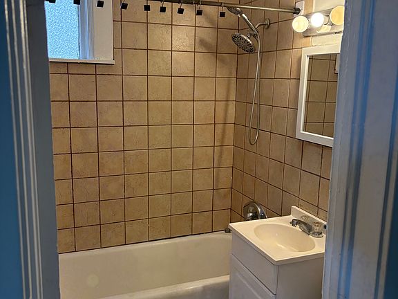 Ceramic tile bathroom with original cast iron tub.