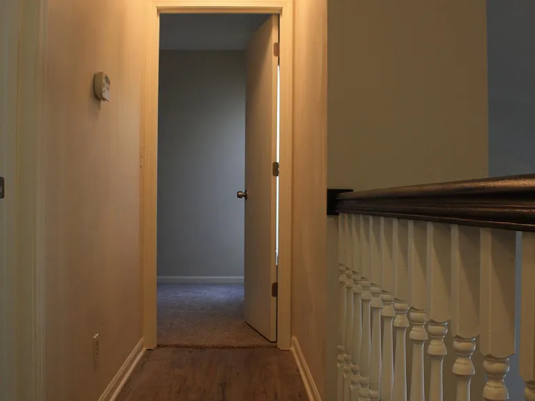 Hallway leading to guest room on the left and at the end.