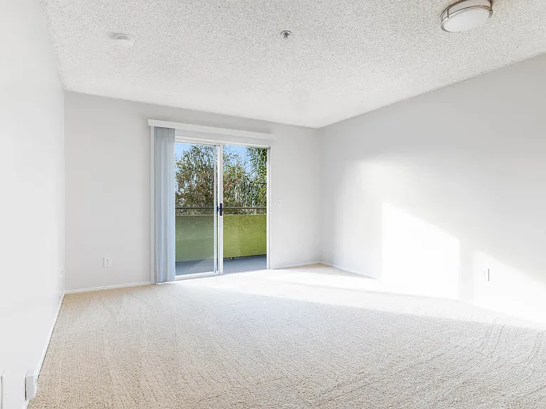Carpeted Living Room with Balcony