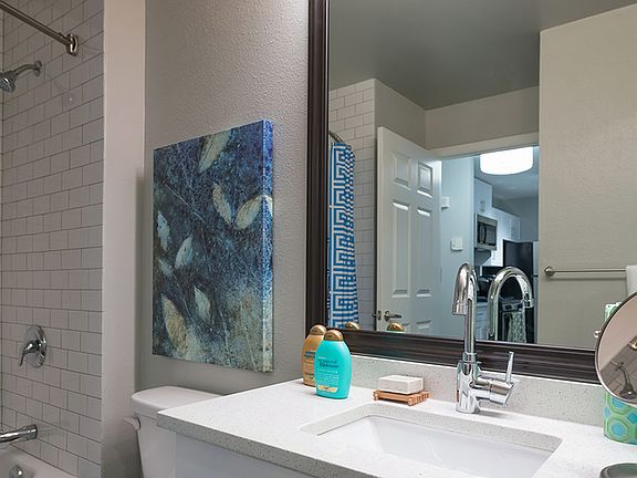Framed vanities, floor to ceiling tile surround, and granite countertops