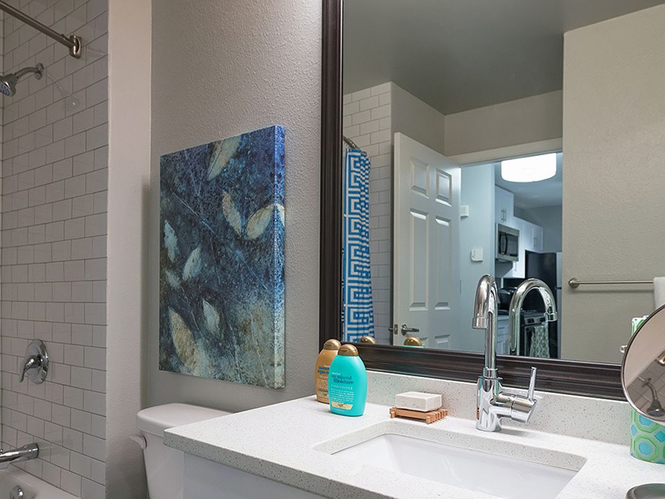 Framed vanities, floor to ceiling tile surround, and granite countertops