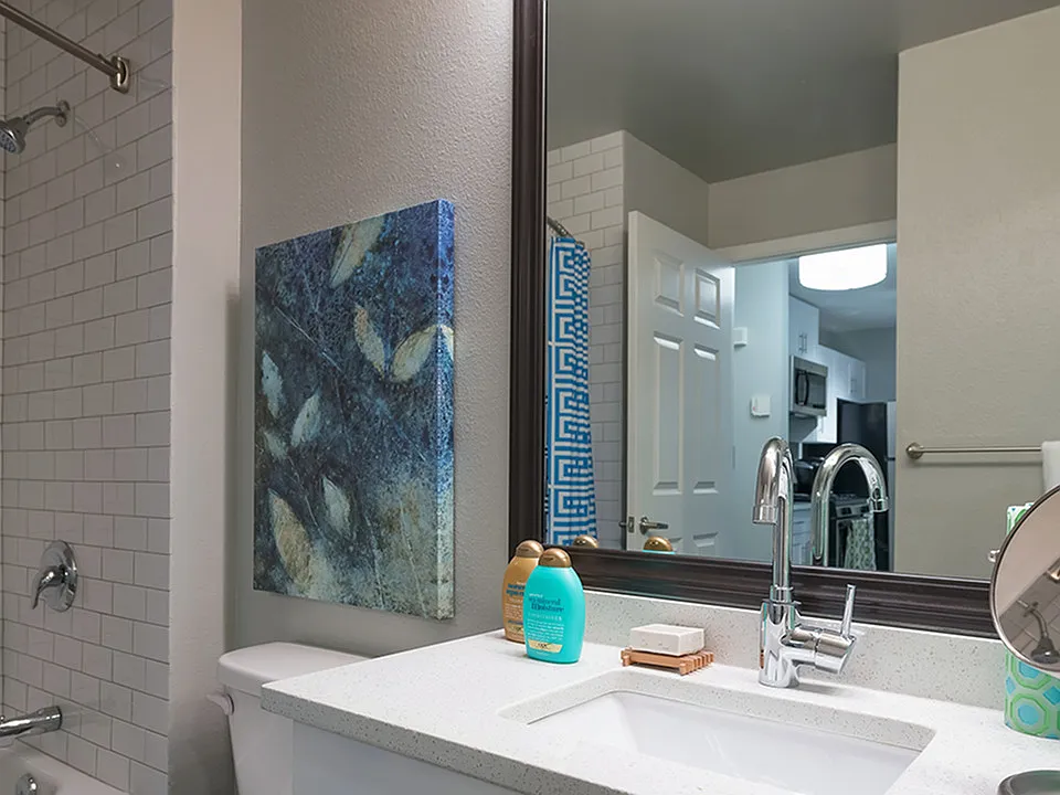 Framed vanities, floor to ceiling tile surround, and granite countertops