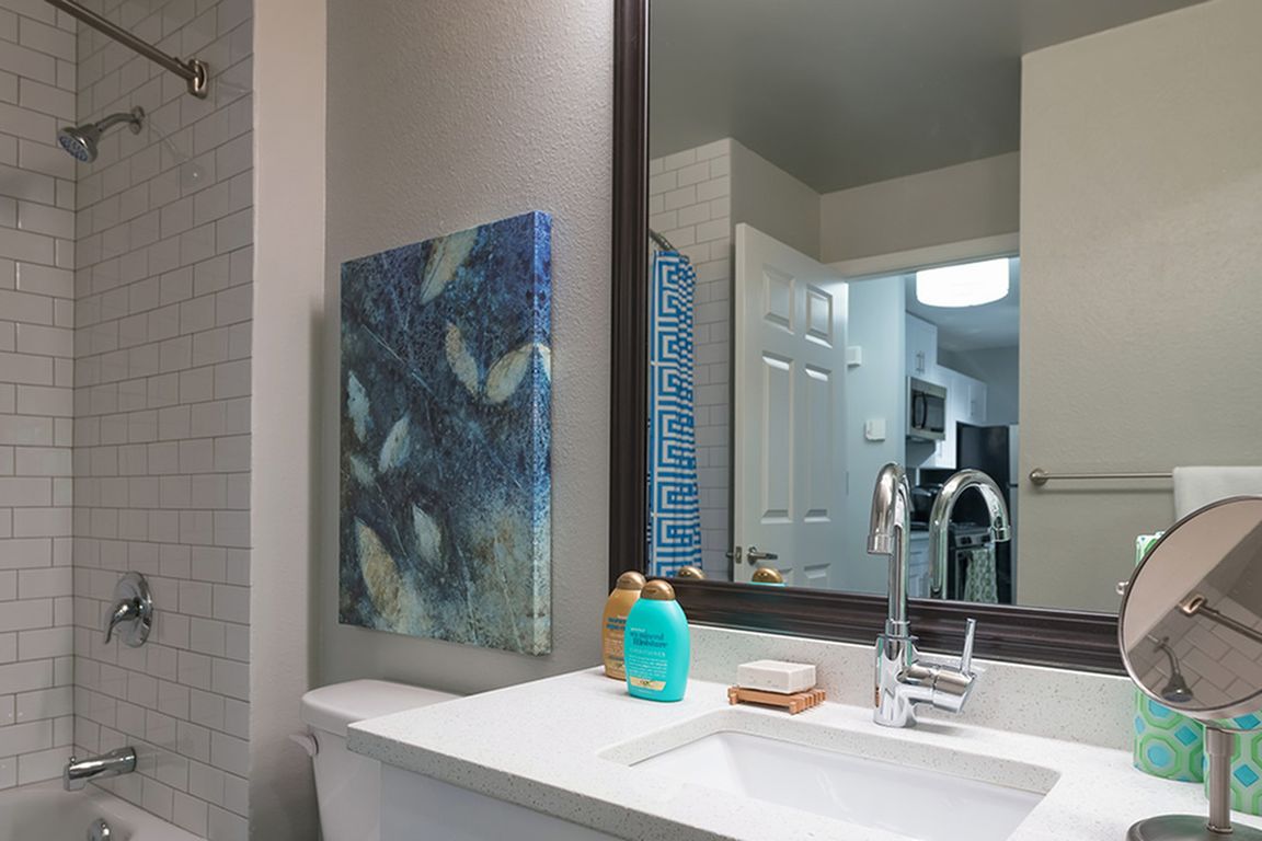 Framed vanities, floor to ceiling tile surround, and granite countertops