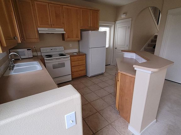 Fully furnished kitchen with electric stovetop, refrigerator, and dishwasher