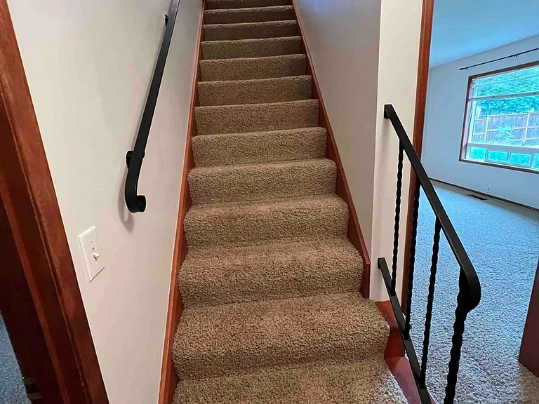 Stairs to 2nd floor with wrought iron railings.