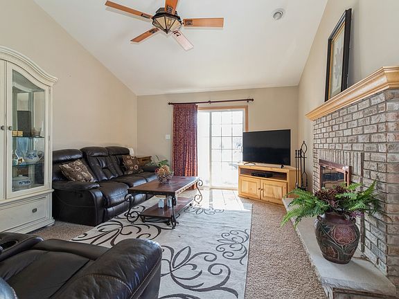 vaulted ceiling in the living room with brick gas starting fireplace and front porch.