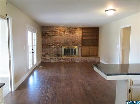 beautiful hardwood flooring in kitchen and family room with used brick fireplace
