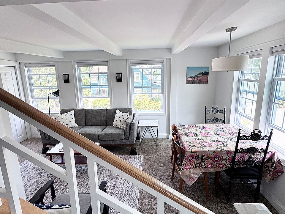 Living and dining area from stairs going to third floor of house where the second bedroom, laundry and full bath are.