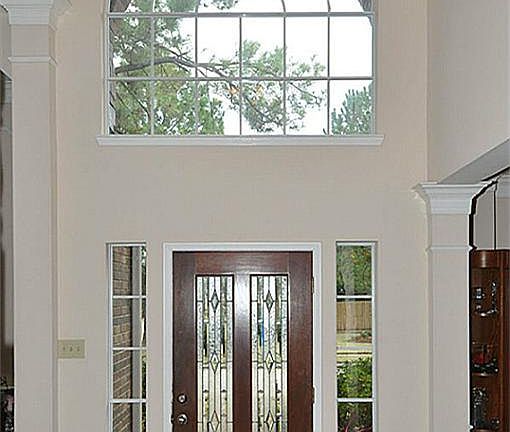 Two story entrance with slate flooring, lead glass front door, custom light fixture, open to formal dining and formal living.