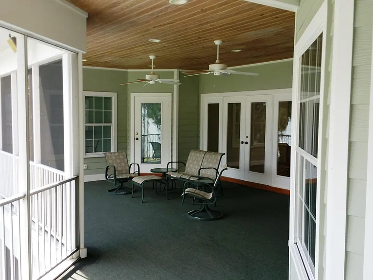 The main screened in porch off of the Foyer. The door to the left leads in to the master BR. the windows to the right lead to the breakfast nook