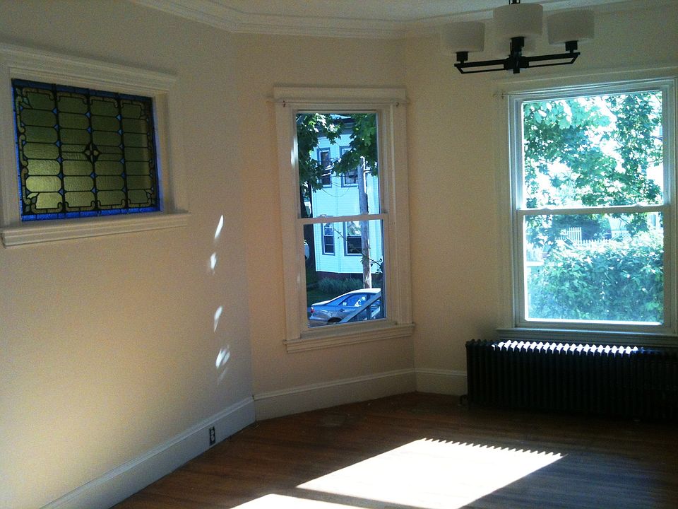 Large living room with stained glass window and tin ceiling.