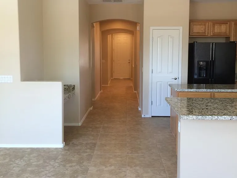 View from dining room looking to front door with small desk/work area to the left across from the kitchen peninsula.