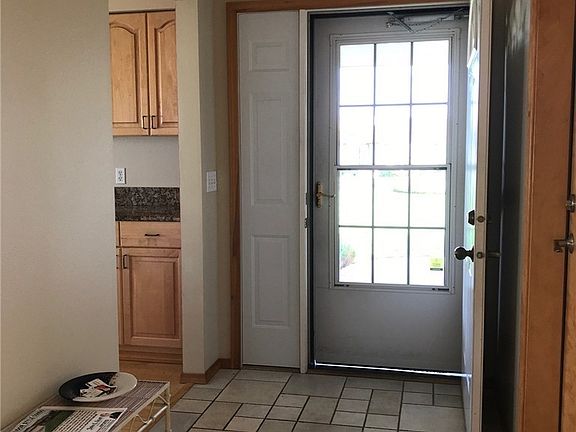 Tiled entry with secure and private side panel by door.