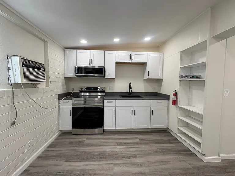 Kitchen with new cabinets, range and microwave.