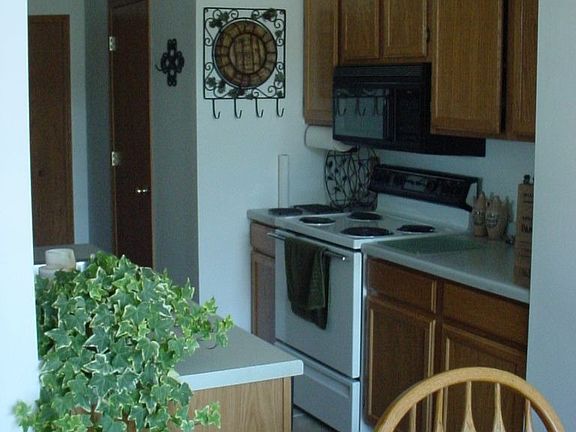 Kitchen features tile floor and oak cabinets