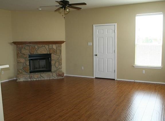 Family room with stone fireplace and laminate wood.