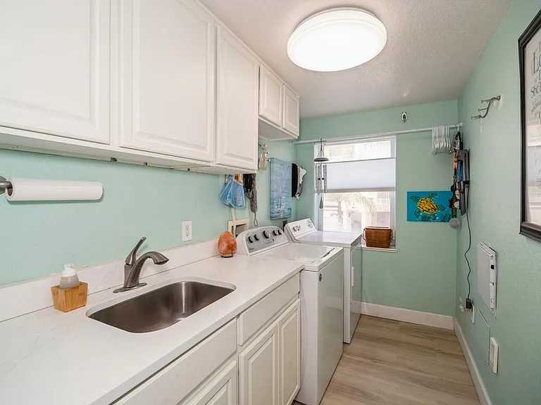 Large laundry room, washer and dryer, laundry sink and storage