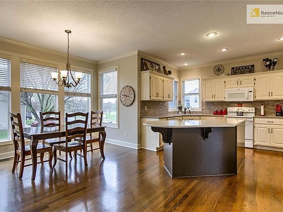Light bright kitchen with gleaming wood floors, granite counters and freshly painted cabinets.