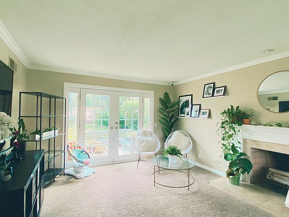 The living room features French doors and a custom wood-burning fireplace with a travertine surround. Extend your outdoor/indoor entertaining space by opening the French doors to the backyard. There is also a large, double-paned window in the living room