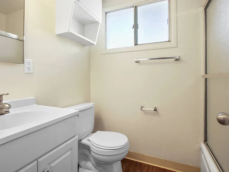 Bathroom with shower and tub combo at the right, single vanity with white cabinet