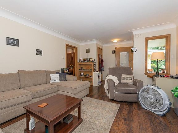 Front living room area with large window , builtin shelve and closet with new laminate wood floors.
