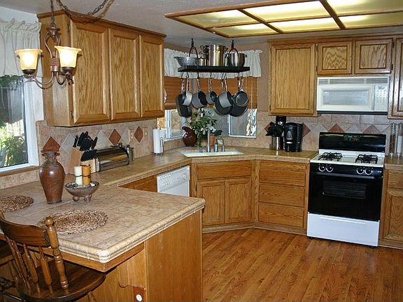 Remodeled kitchen features new flooring and tile counters.