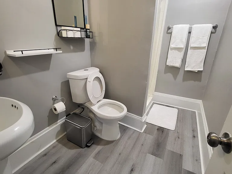 Modern bathroom with small medicine cabinet and shelving. Clean towels are included.