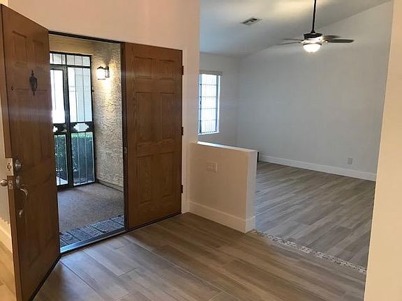 Front Double Door with screened key locking patio. Great for cross ventilation and extra privacy. Living room to the left of the front door with a mounted TV.