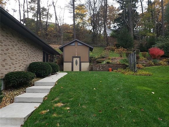 Side view of house with sidewalk leading to 2 story storage shed