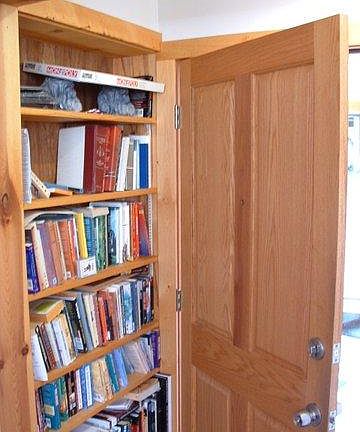 built-in bookshelf behind entrance door.