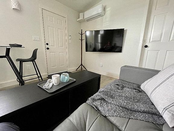 Here's a view of the "Great Room" from the loveseat. Note the front door and dining set on the left, your 50" television, A/C-heat, and fast wifi router. The coffee table also works great under the TV.