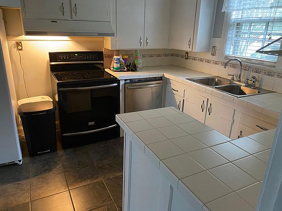 Kitchen with fridge, dishwasher and garbage disposal.