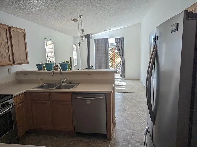 Kitchen looking into the family room and outdoor covered sitting area through sliding glass doors