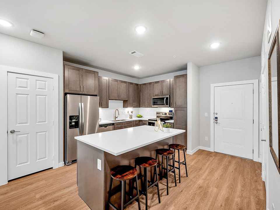 Experience the perfect blend of style and functionality in this modern kitchen. Featuring sleek dark wood cabinetry, a spacious island with a quartz countertop, and stainless steel appliances, this space is designed to impress. Enjoy the convenience of am